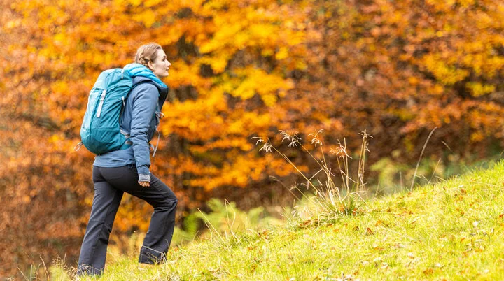 Wandern im Herbst | © DAV / Franz Günther Wandern im Herbst: Eine Frau genießt die herbstliche Stimmung in den Bergen. Das Laub ist bereits bunt verfärbt | © DAV / Franz Günther